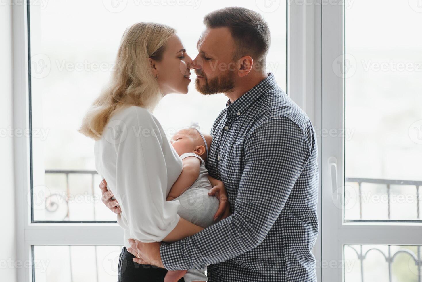 View at Happy family with newborn baby by the window photo