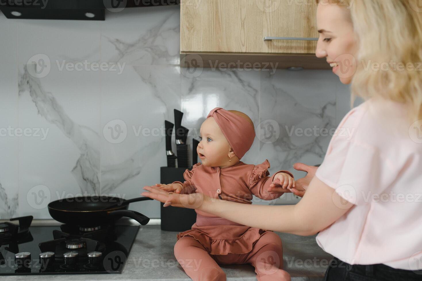 Woman cooking with her little daughter in hands photo