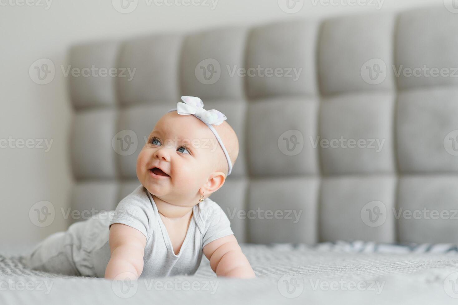 A Baby girl in white bedding at home look nice photo