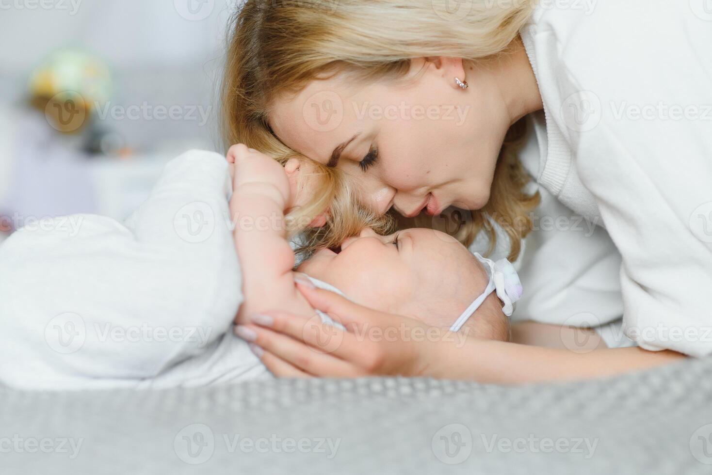 Portrait of young mother with cute baby at home photo