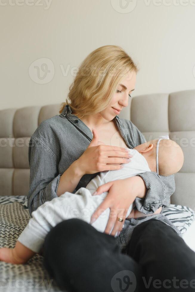 Soft photo young mother feeding breast her baby at home in white room