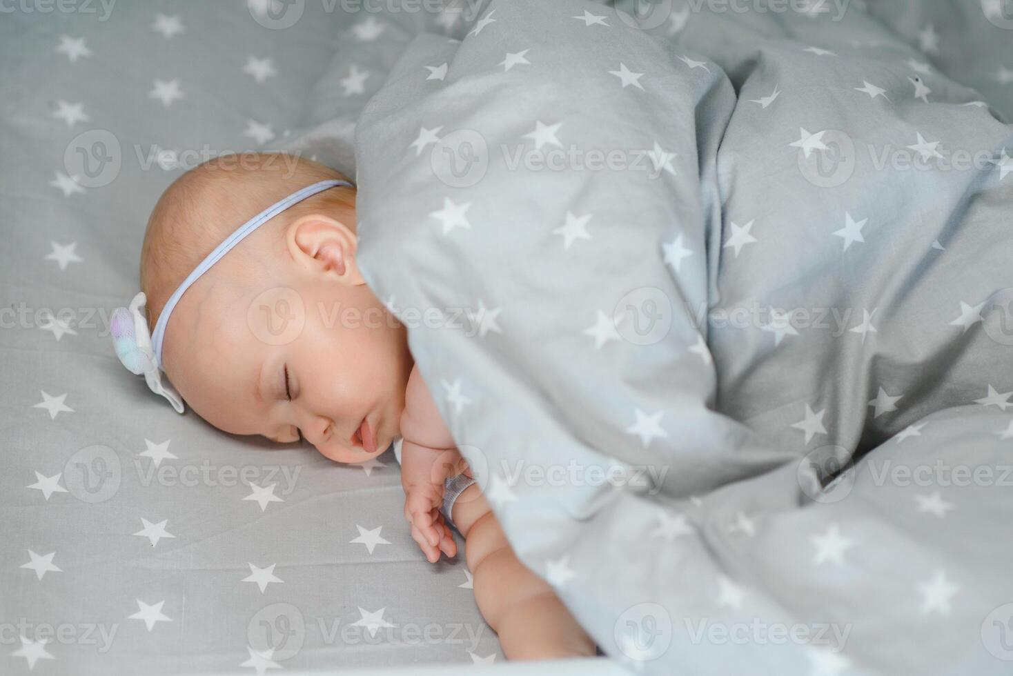 Adorable baby girl sleeping in the crib. Little child having a day nap in cot. Infant kid resting in nursery photo