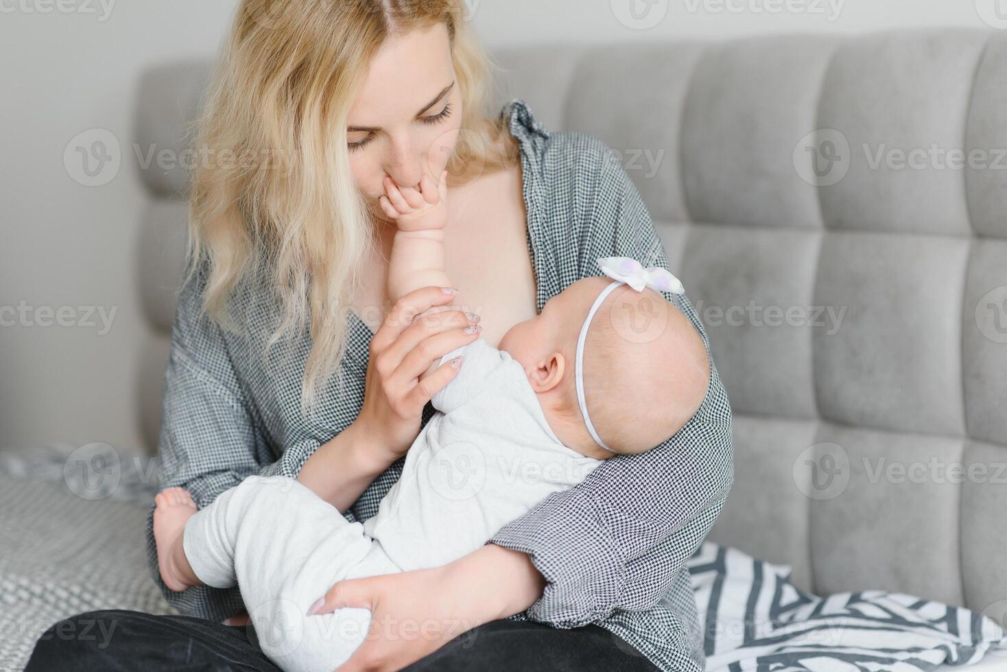 Lactation concept. Young mother breastfeeding her newborn baby at home, close up photo
