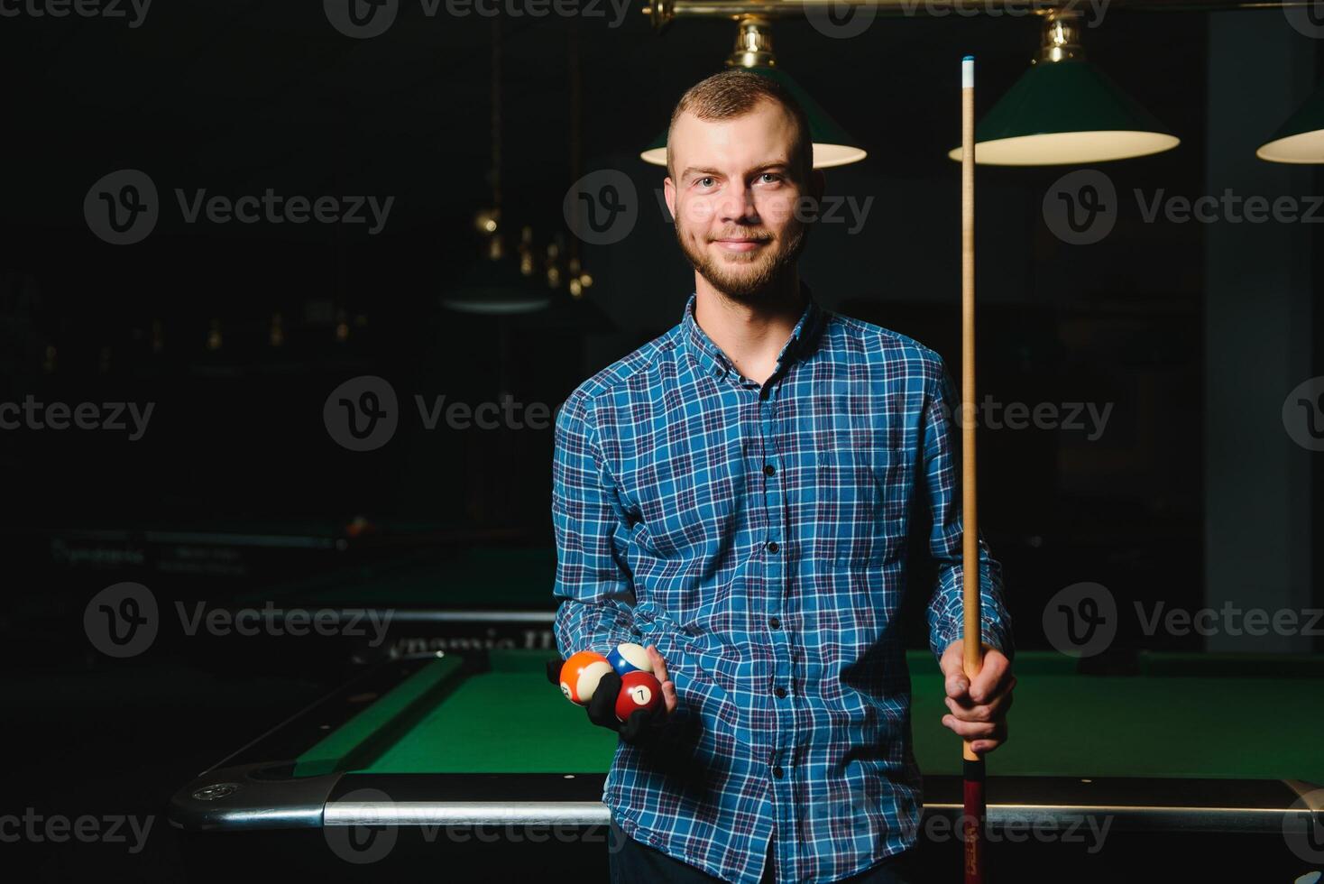 Thoughtful man plays billiards. Billiard room on the background. photo