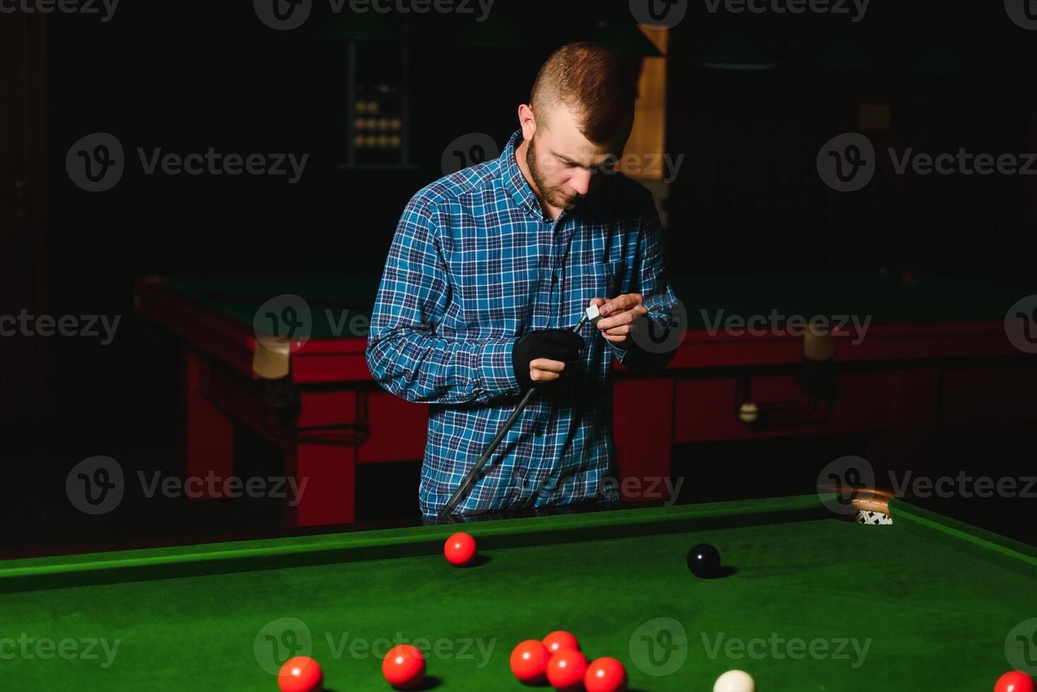 portrait of a young man playing billiards photo