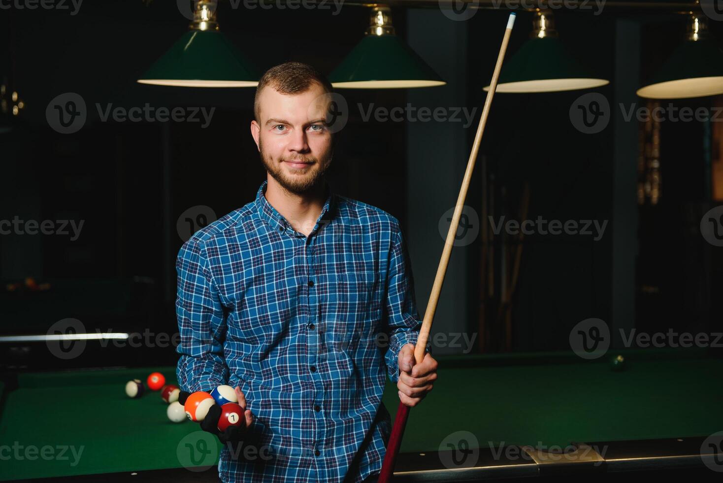 Thoughtful man plays billiards. Billiard room on the background. photo