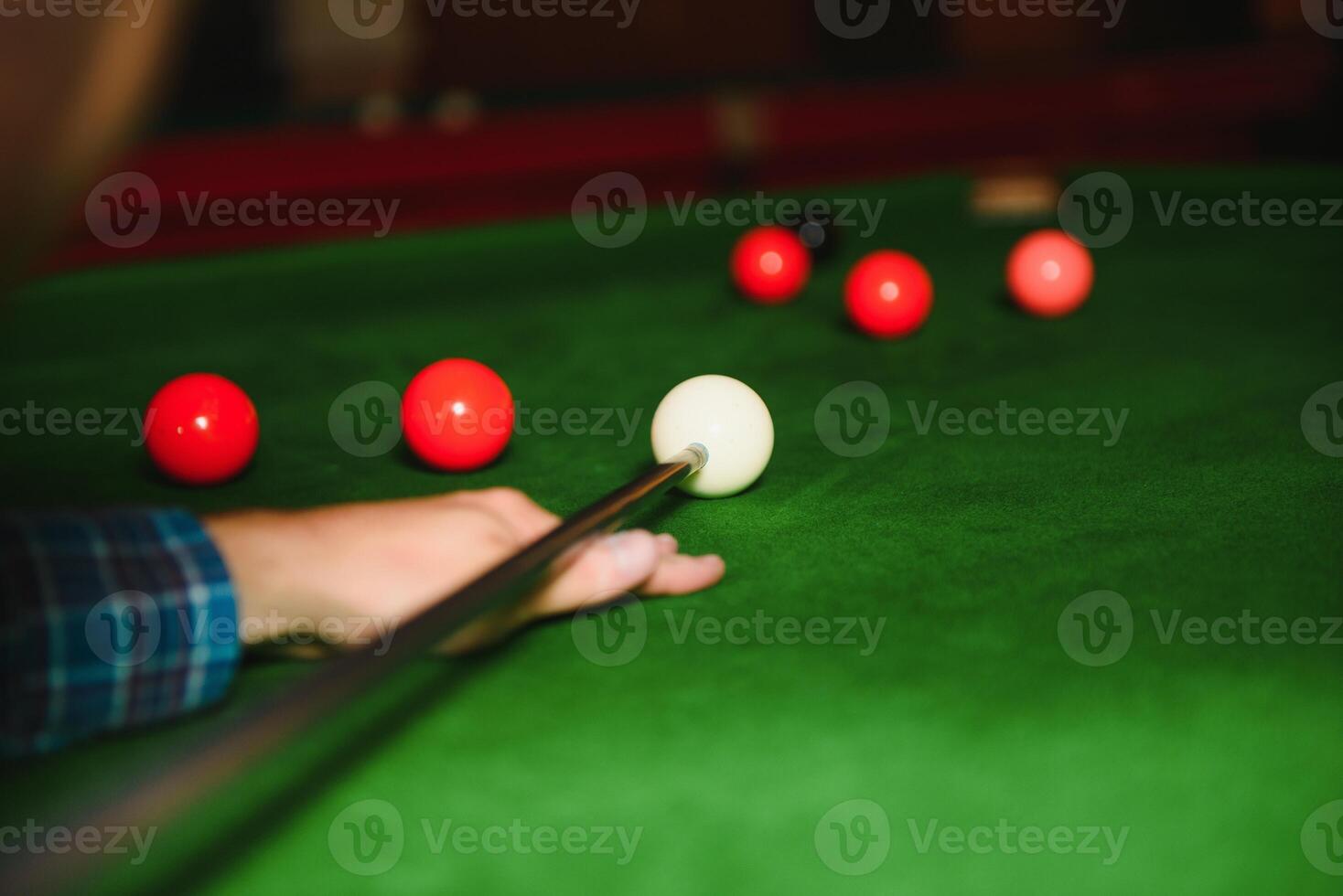 portrait of a young man playing billiards photo
