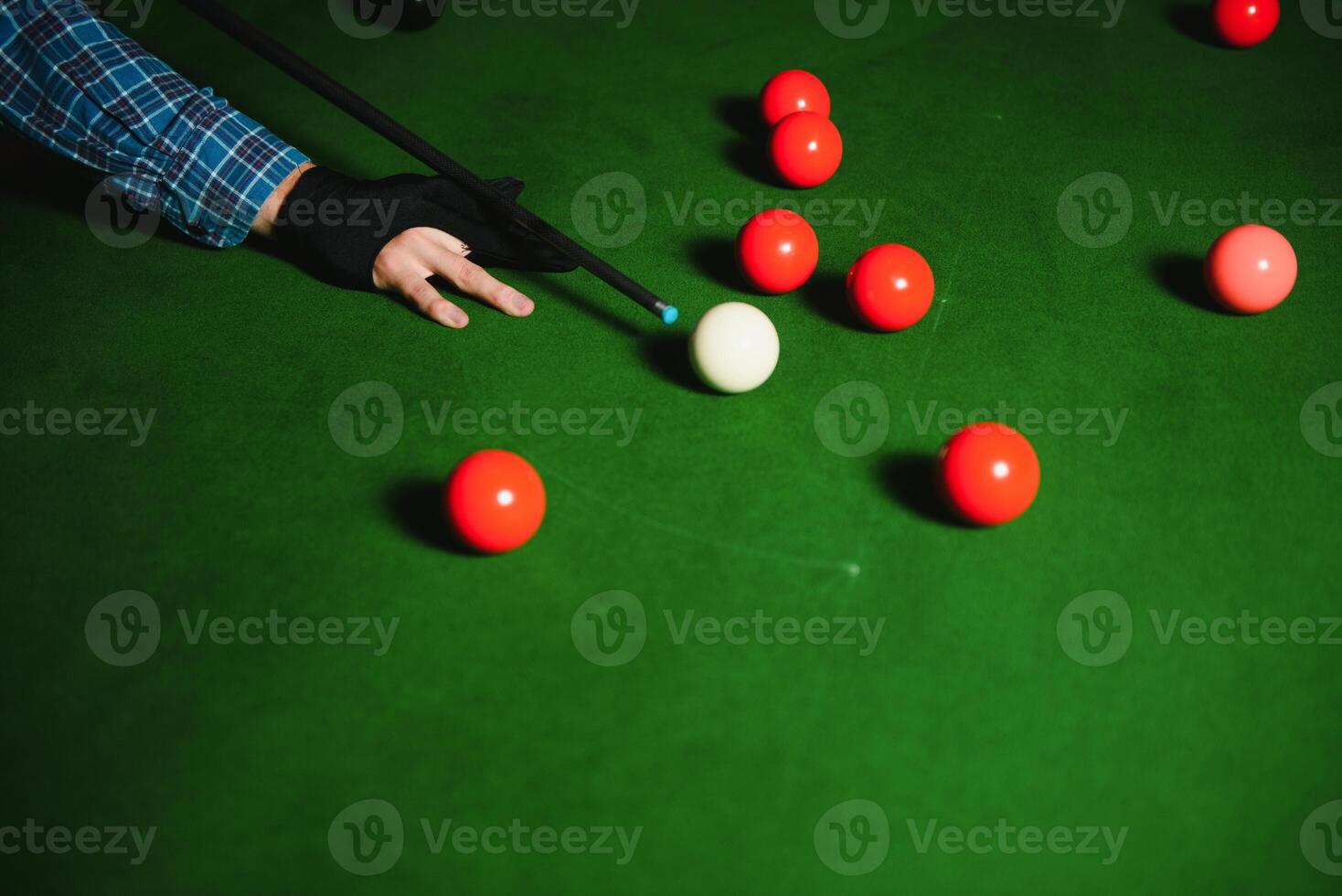 Thoughtful man plays billiards. Billiard room on the background. photo