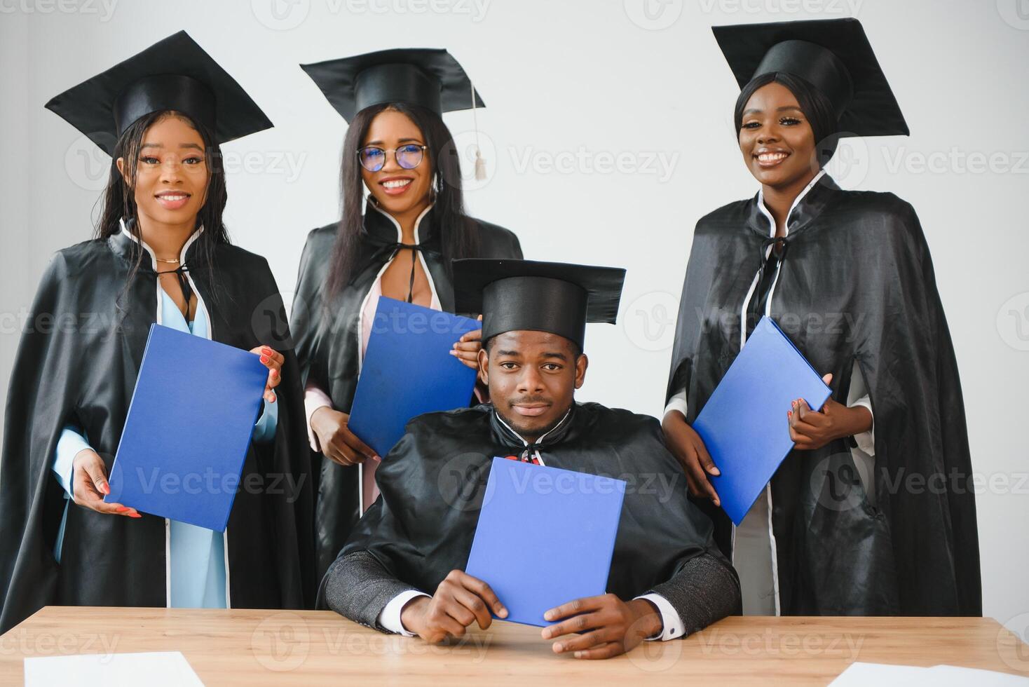 portrait of multiracial graduates holding diploma photo