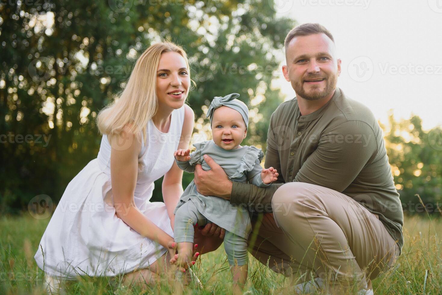 Happy young family spending time together outside in green nature. photo