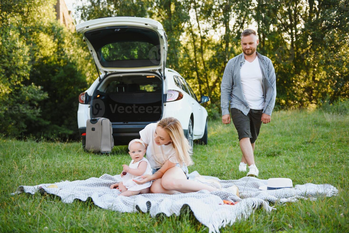 Family in a forest. People by the car. Sunset background. photo