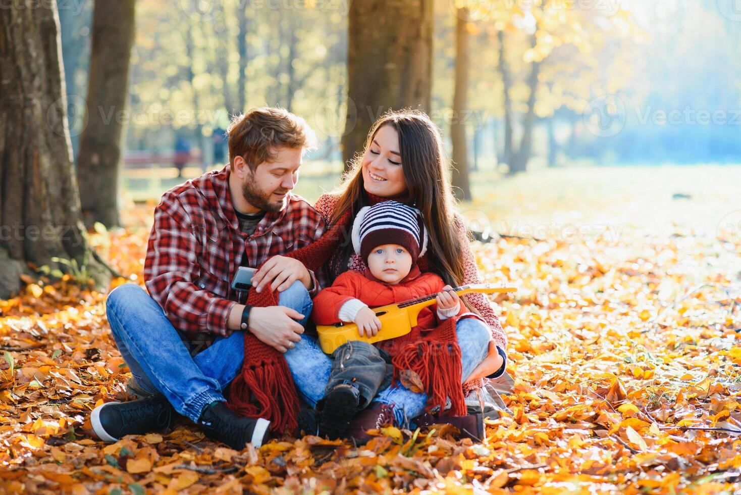 happy young family spending time outdoor in the autumn park photo