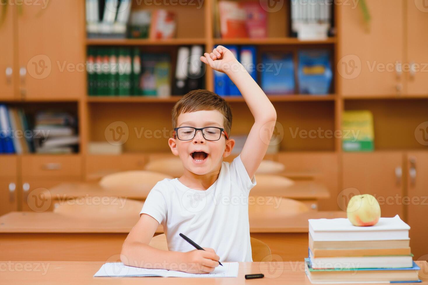 Elementary school boy at classroom desk trying to find new ideas for schoolwork. photo