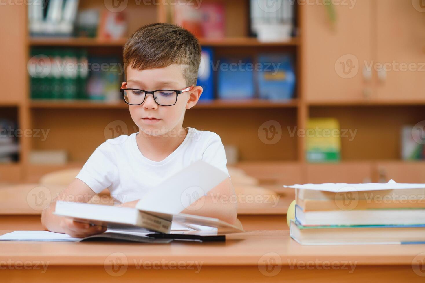 Happy schoolboys sitting at desk, classroom photo