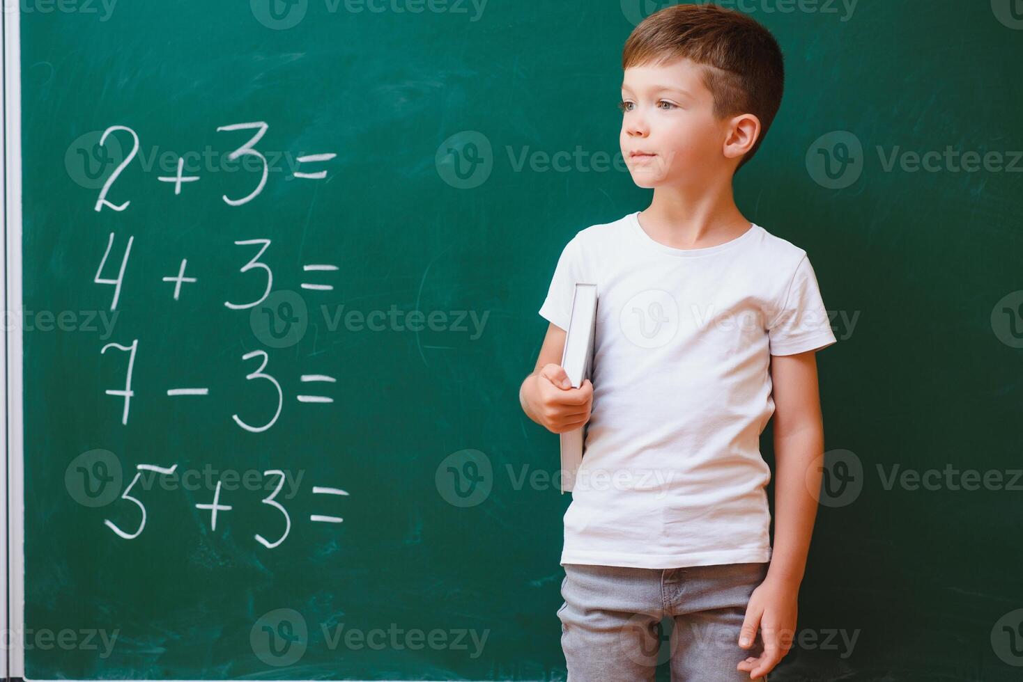 Back to school concept. School child in class. Happy kid against green blackboard. Smart child in classroom. Idea and education concept photo