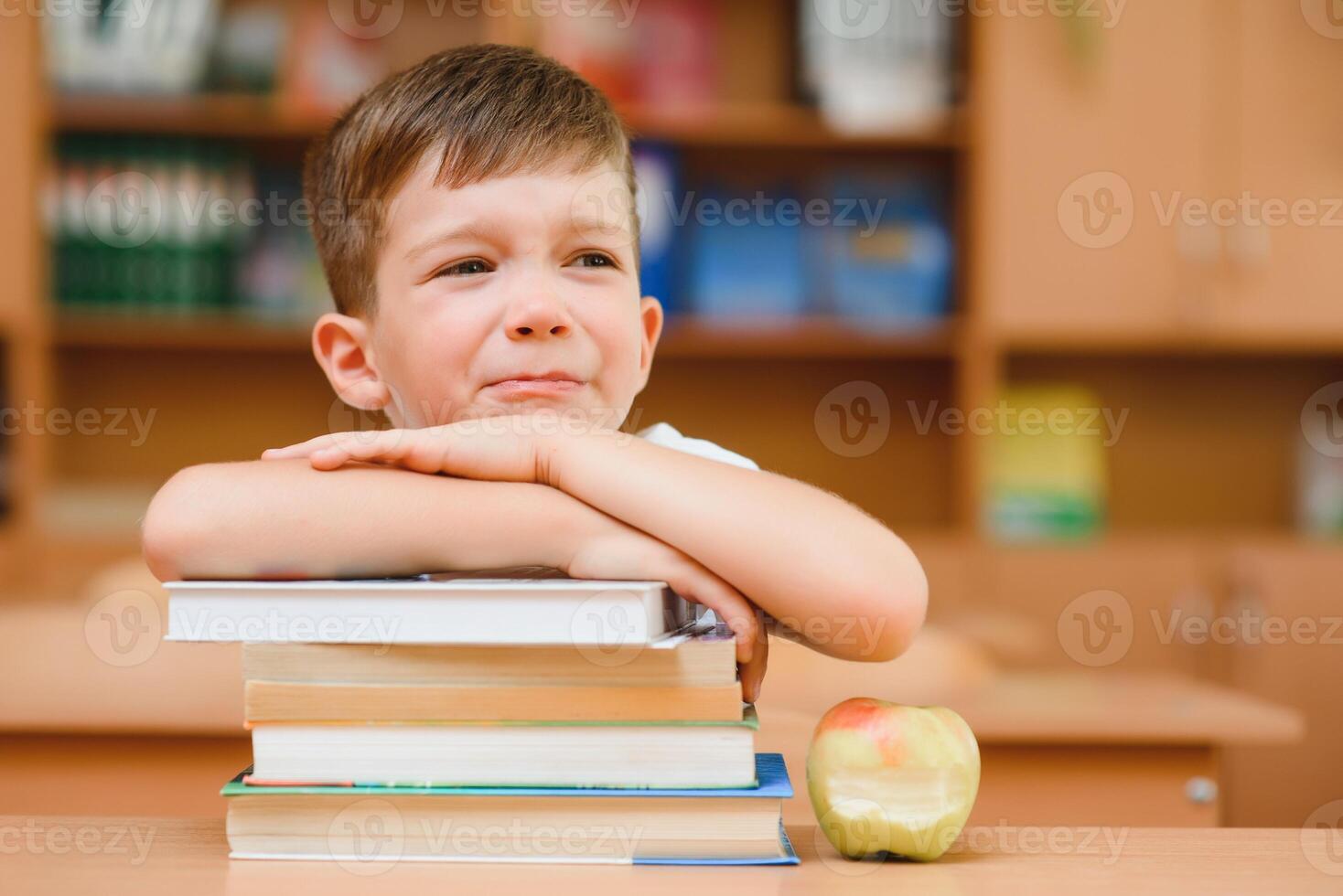 education and school concept - smiling little boy with many books at school photo