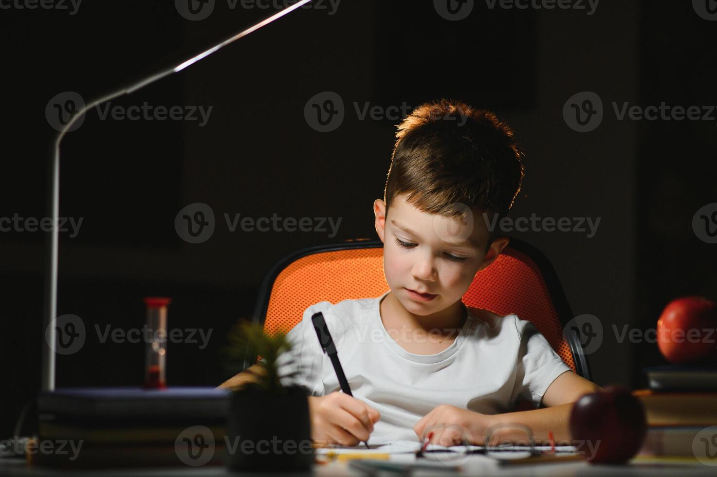boy doing homework at home in evening photo