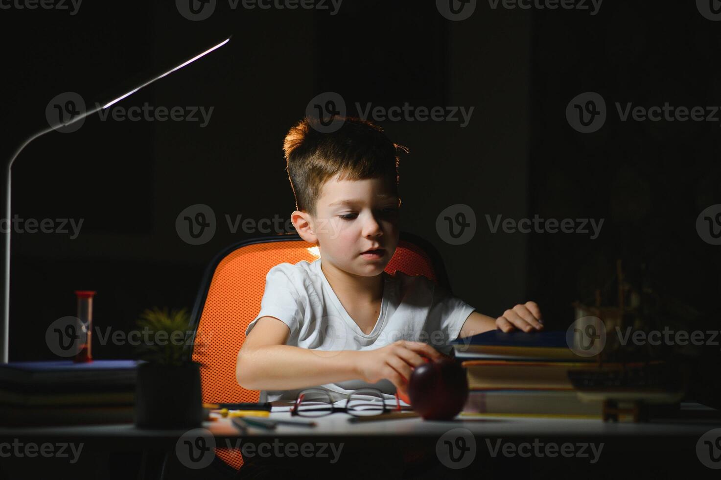 boy doing homework at home in evening photo