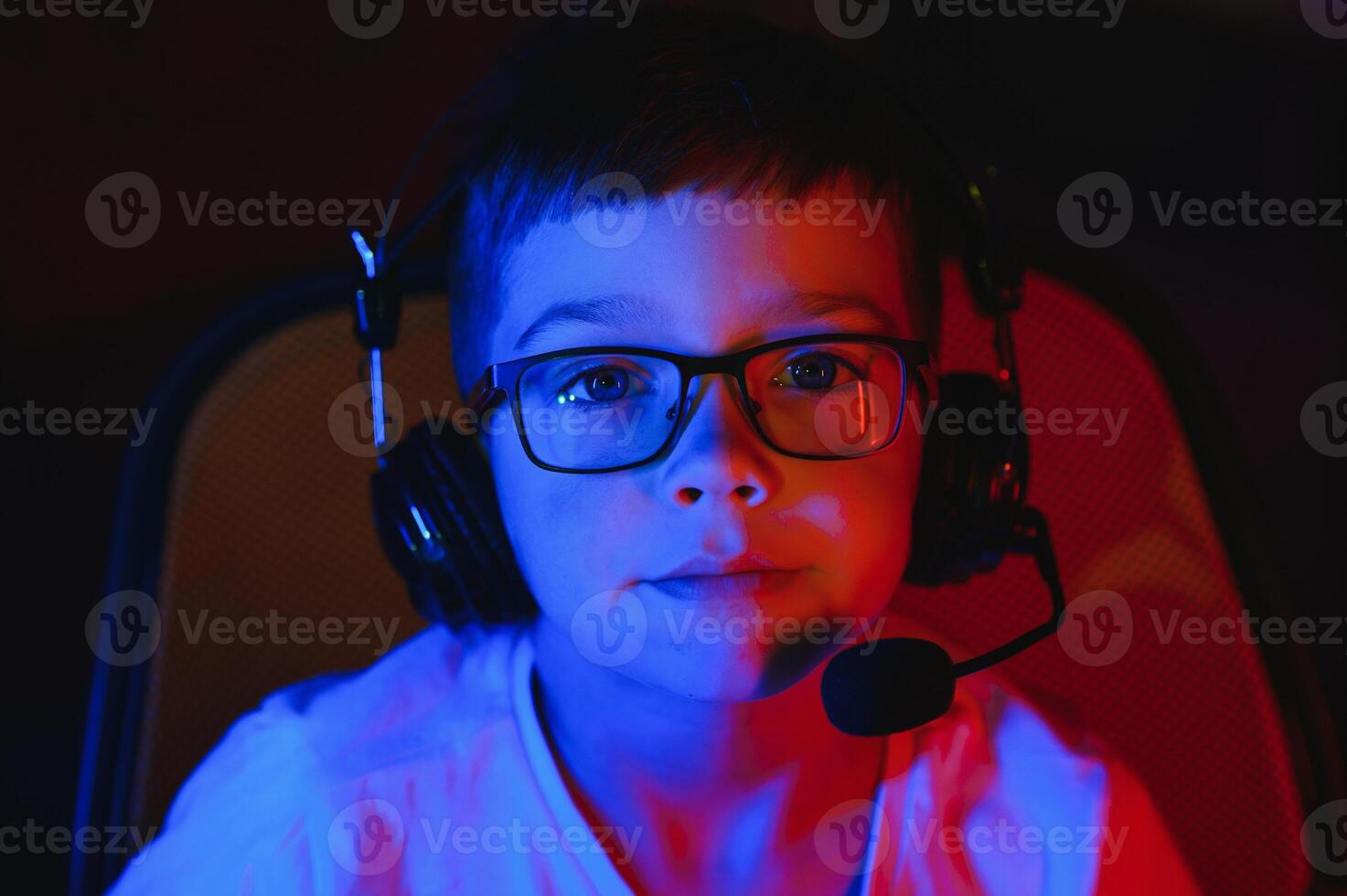 Little boy playing game in the dark room photo