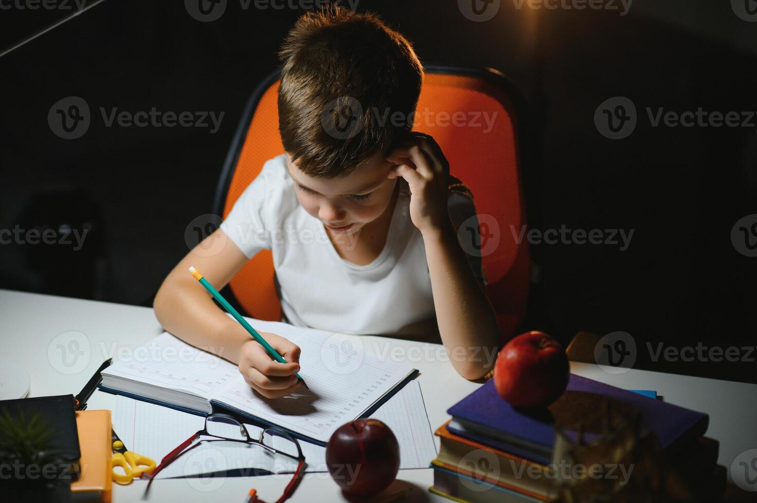 Little boy painting in a dark room late in the evening photo