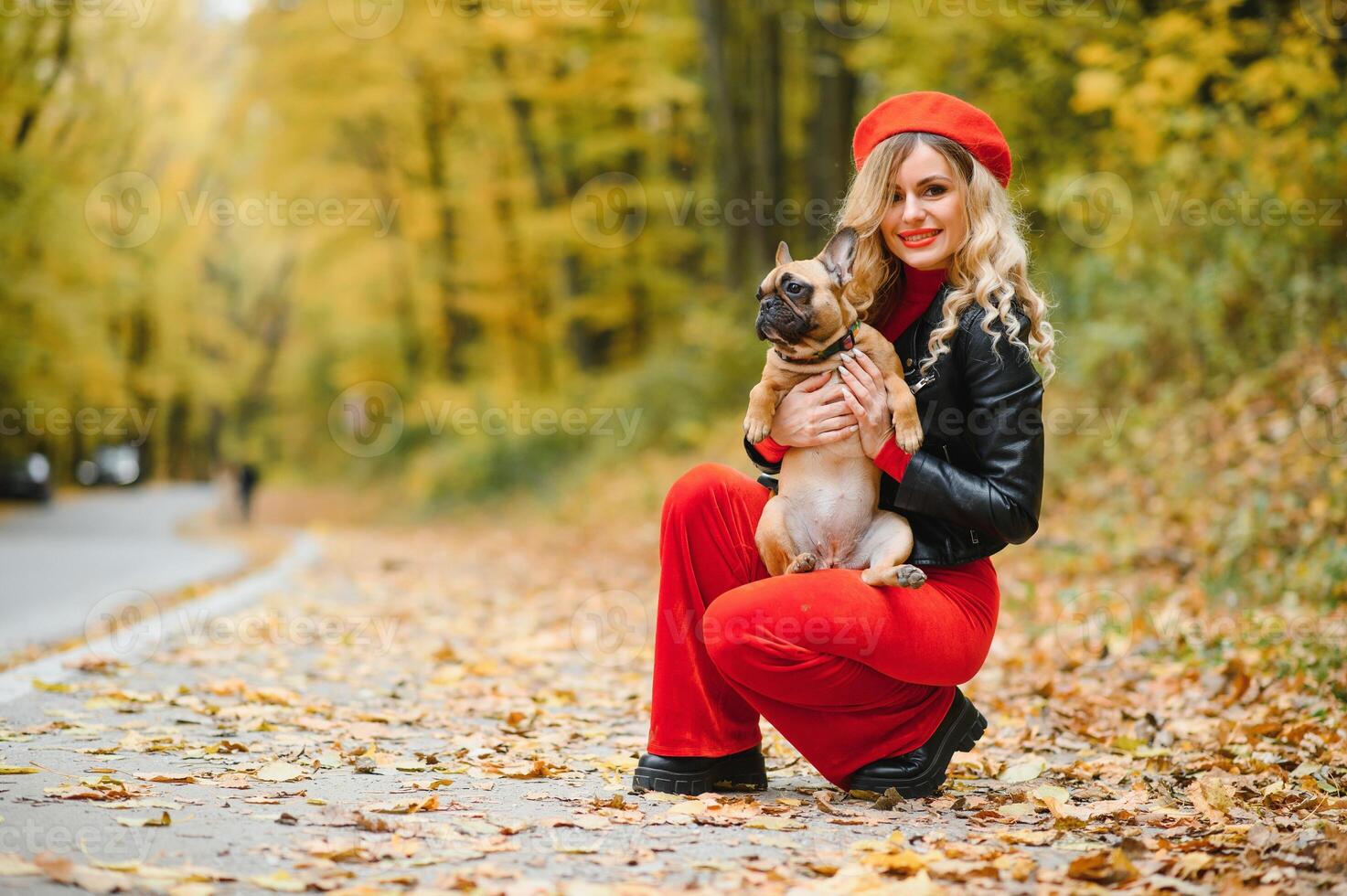 Beautiful and happy woman enjoying in park walking with her adorable French bulldog. photo