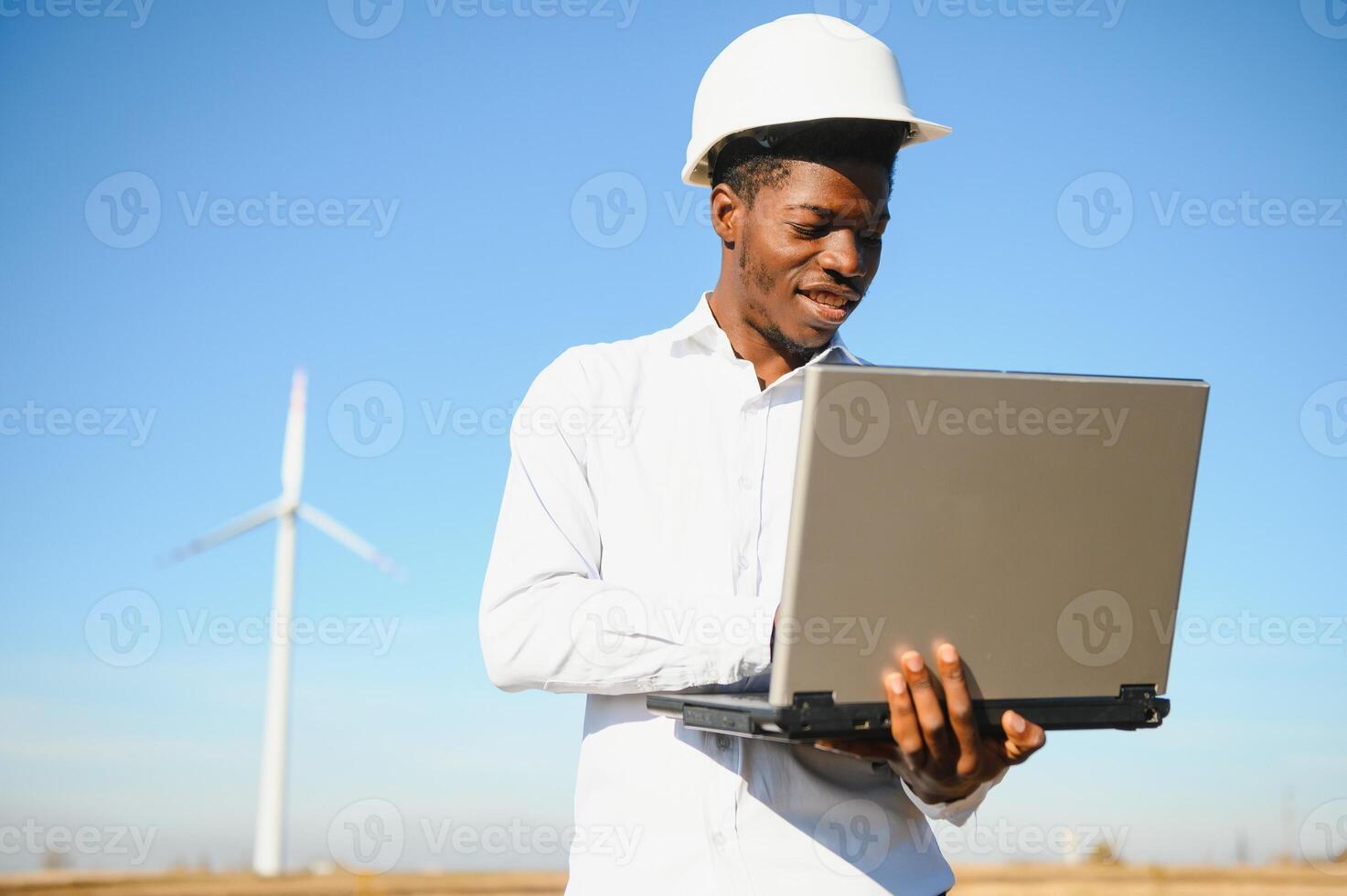 Engineer African man standing with wind turbine photo