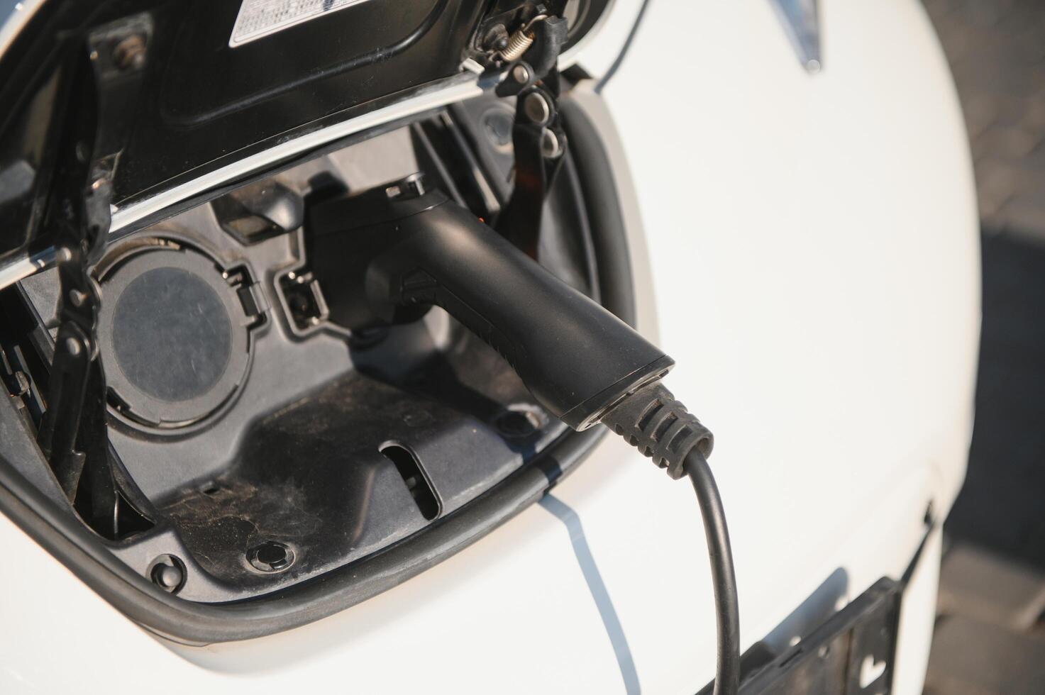 Charging modern electric car battery on the street which are the future of the Automobile, Close up of power supply plugged into an electric car being charged for hybrid . New era of vehicle fuel. photo
