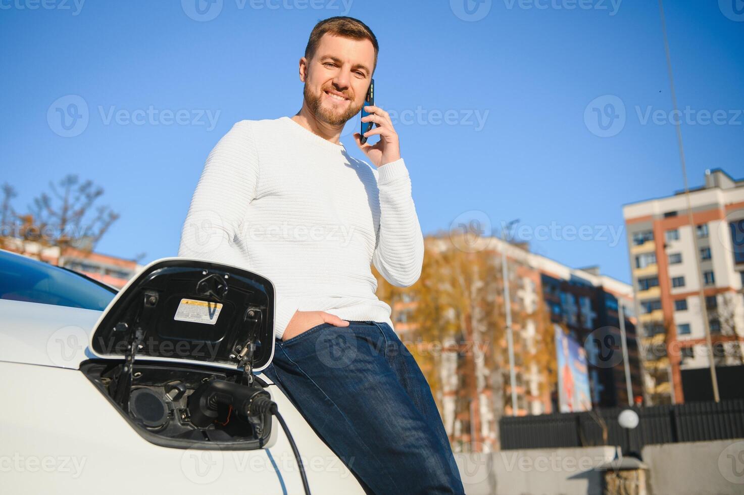 Young man charging his car photo