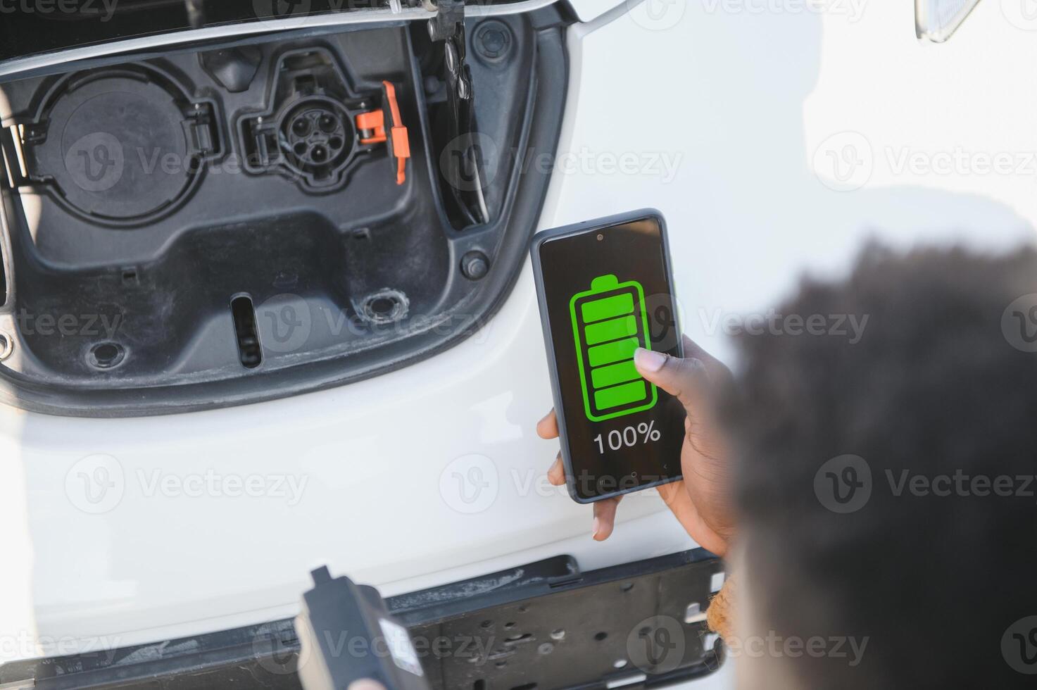 Smartphone app shows charging status of the electric car battery. Electro transport concept photo