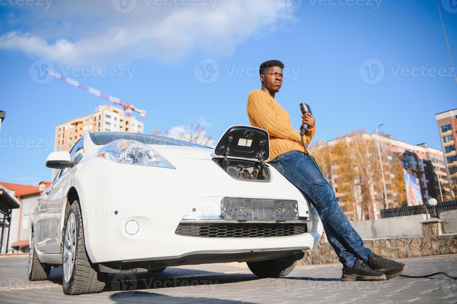 African American man charging his electric car. photo