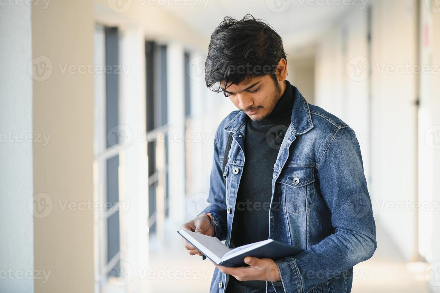 Portrait of indian college boy holding books. photo