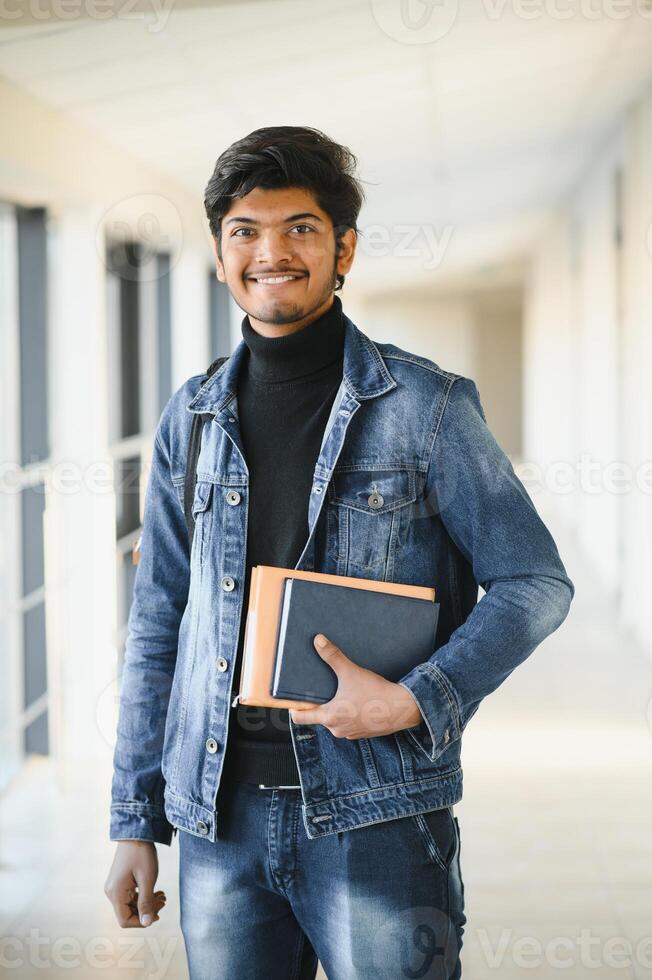 Portrait of indian college boy holding books. photo