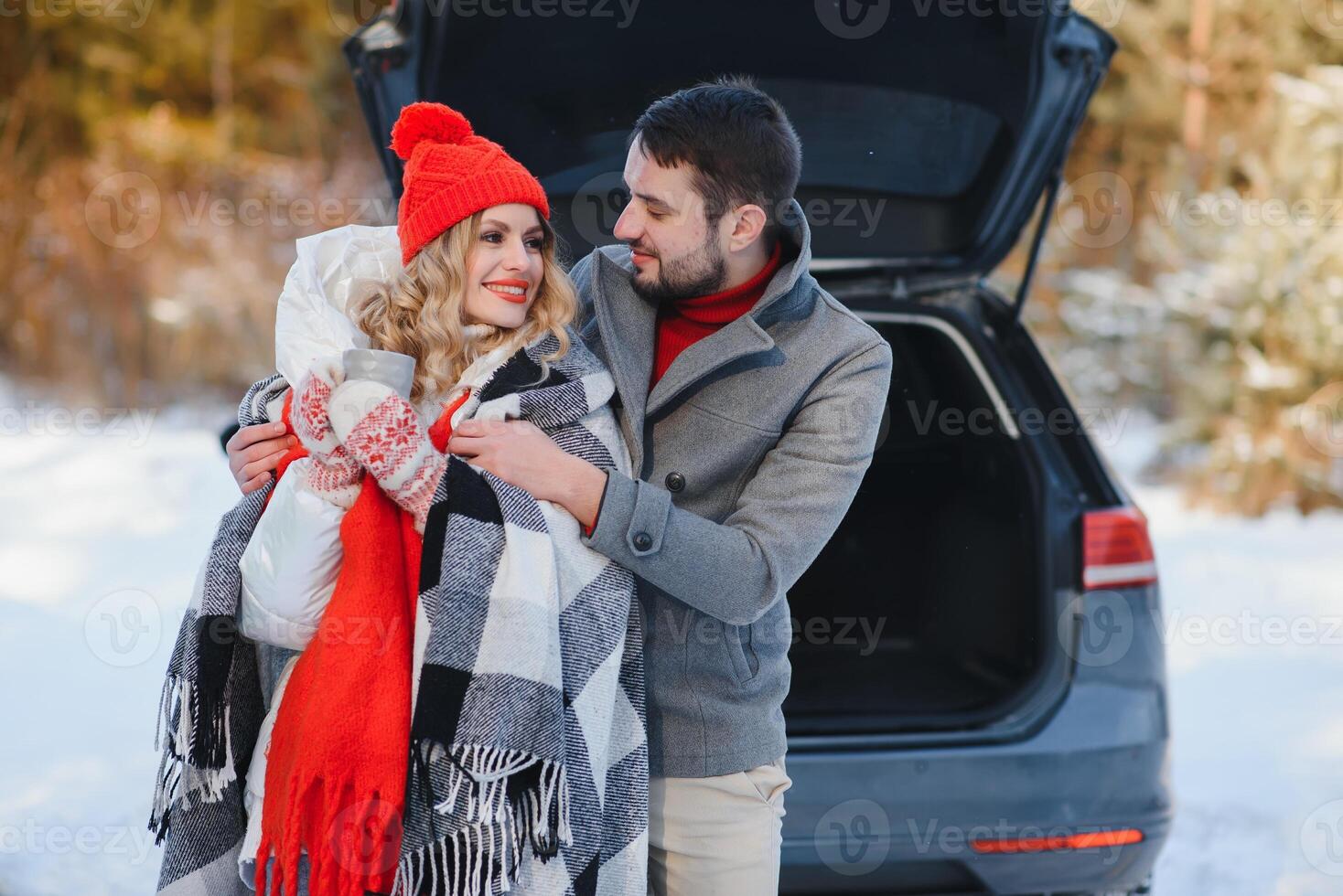 young couple sheltered red plaid holding a hot tea photo
