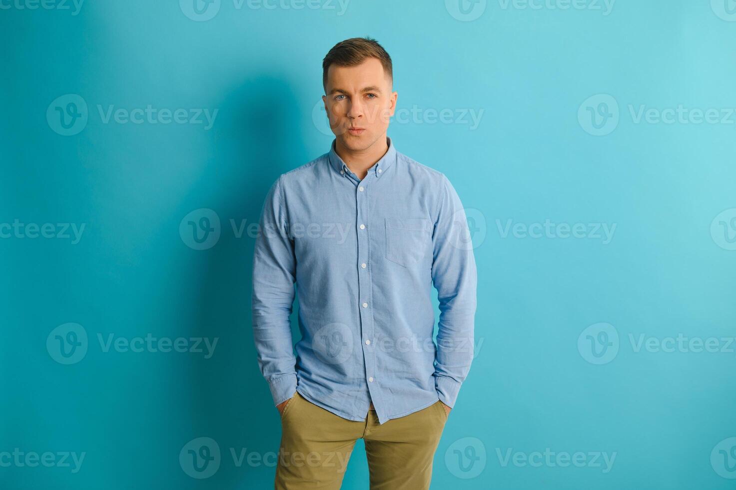 Portrait of handsome young man with beautiful big white toothy smile posing on blue background. photo
