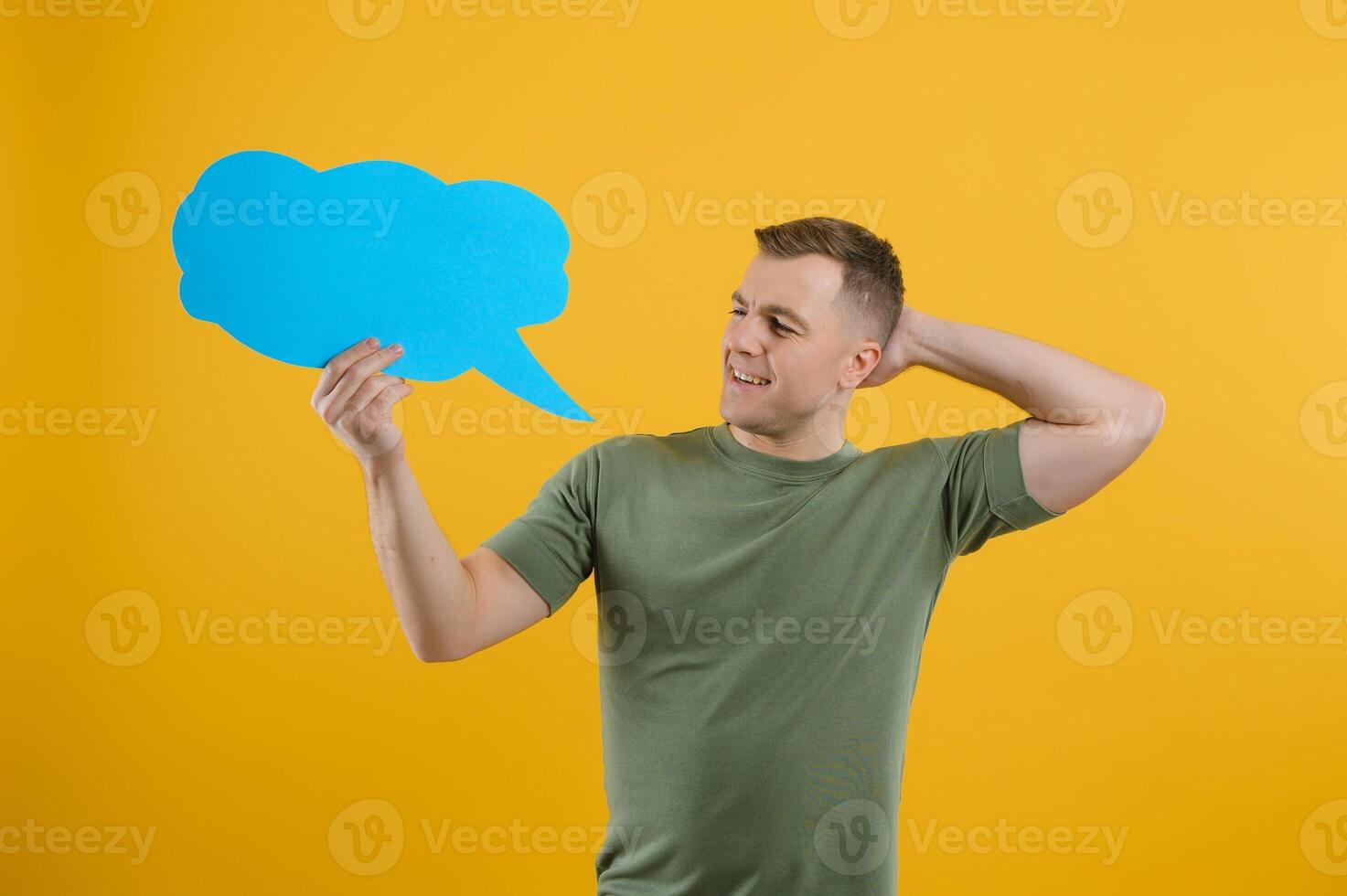 Young caucasian man isolated on yellow background holding a thinking speech bubble and doing OK sign photo