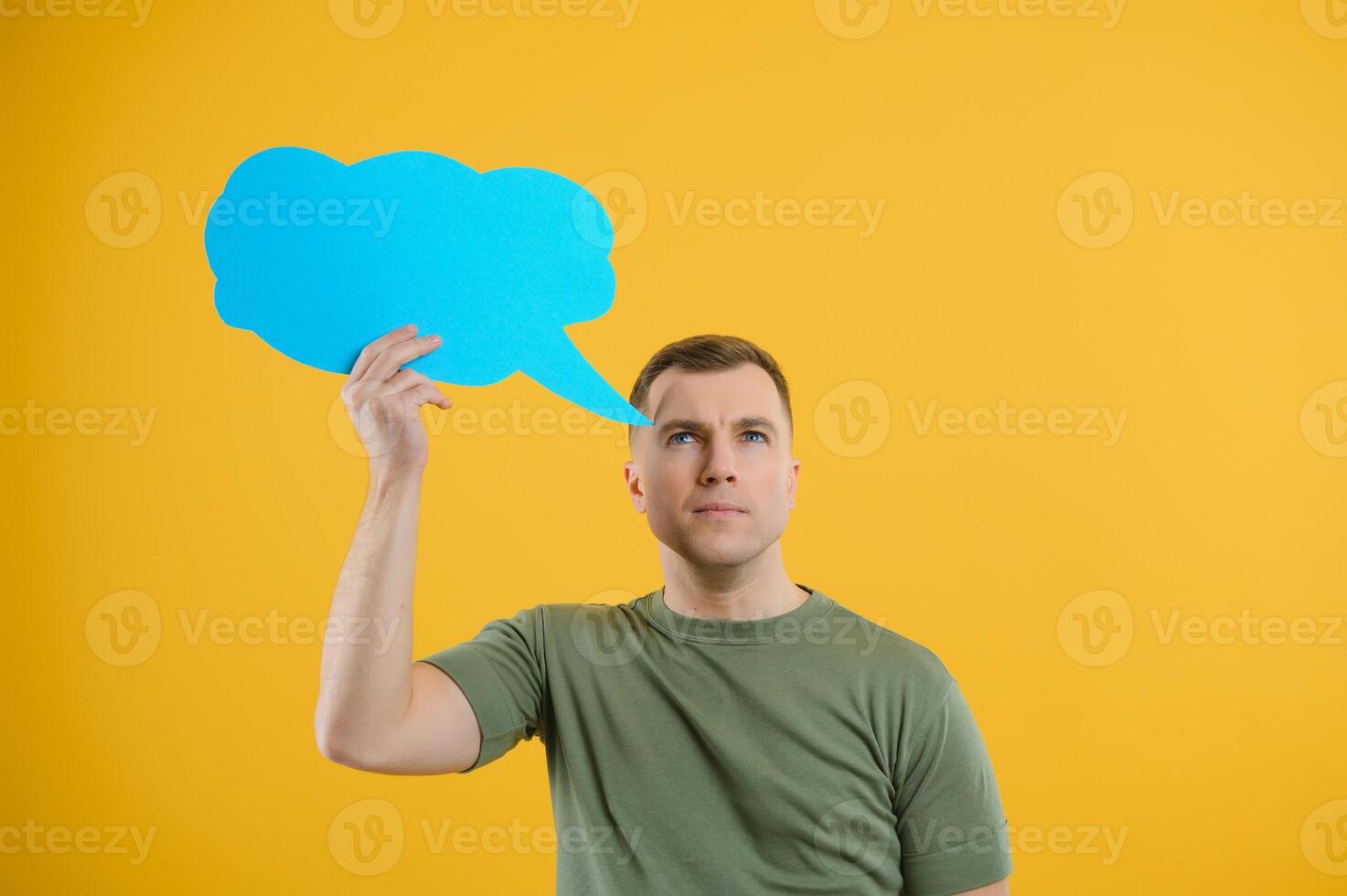 Young caucasian man isolated on yellow background holding a thinking speech bubble and doing OK sign photo