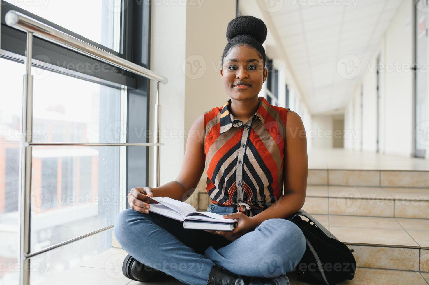 Happy smiling african-american student girl with backpack at university background. Technology, education, leisure concept photo