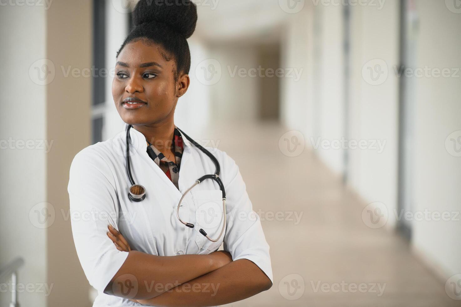 Closeup portrait of friendly, smiling confident female healthcare professional with lab coat, stethoscope. Isolated hospital clinic background. Time for an office visit photo