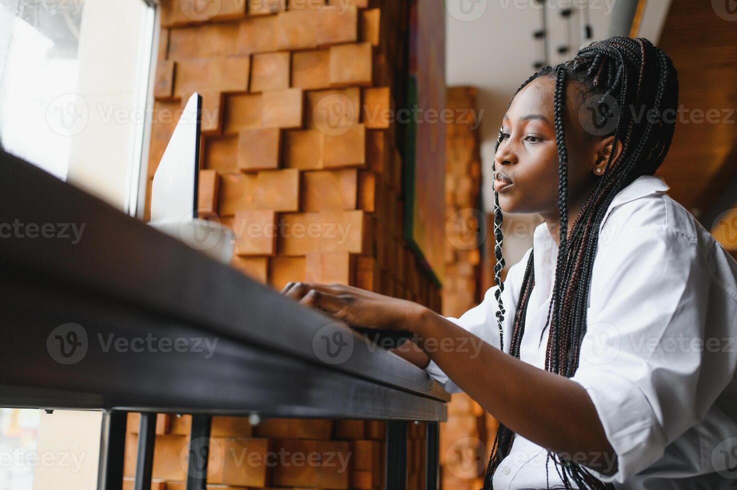 Happy african american woman worker using laptop work study at computer in loft office or cafe, smiling mixed race female student freelancer using pc app dating communicating online watching webinar photo