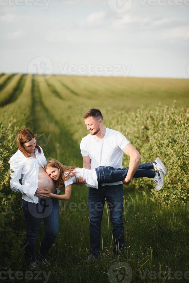 Pregnant woman with her family looking happy photo