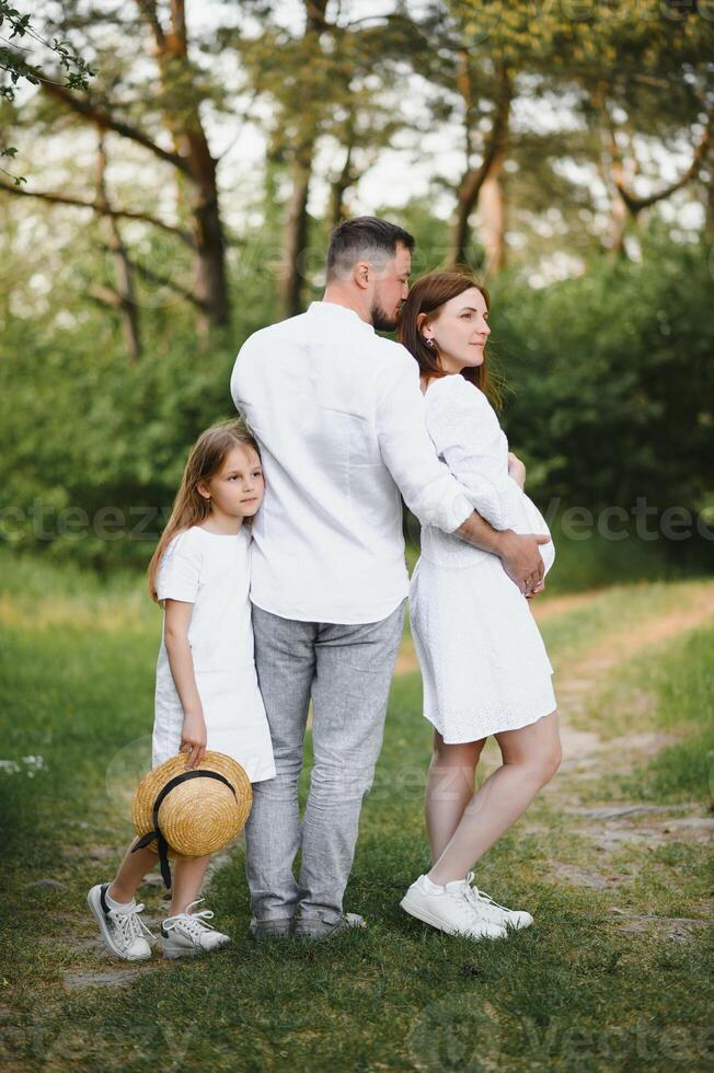 Pregnant woman with her family looking happy photo