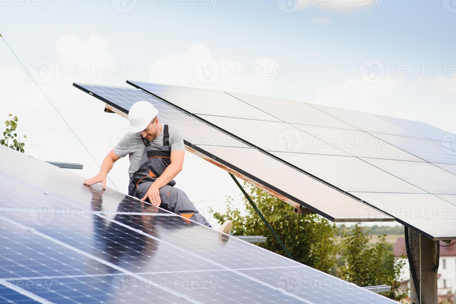 Male engineer in protective helmet installing solar photovoltaic panel system. Alternative energy ecological concept. photo