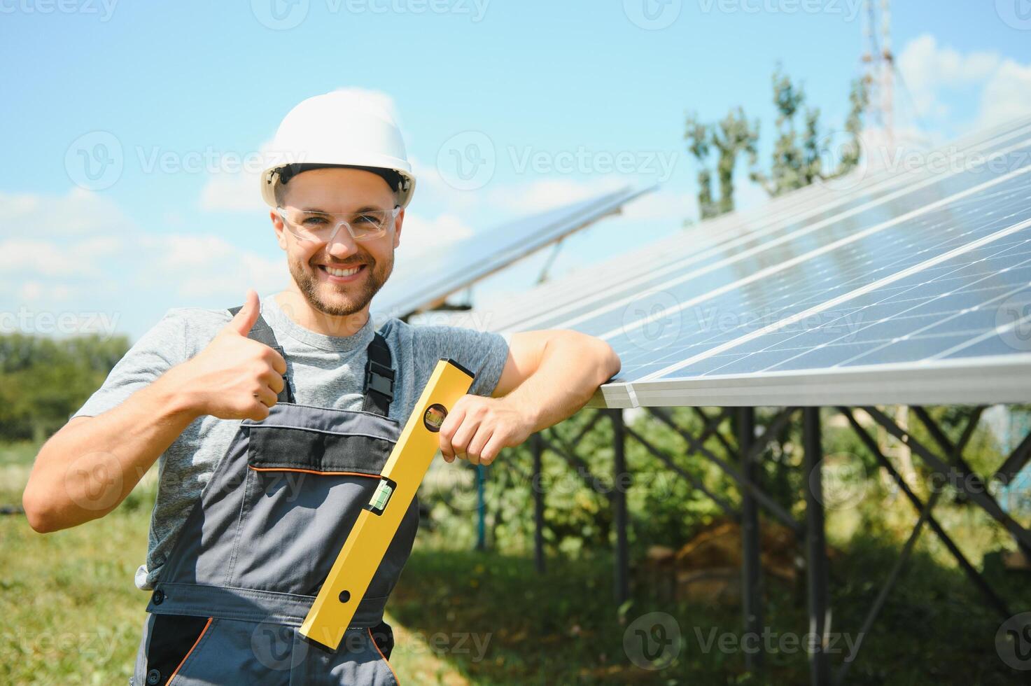 Male worker with solar batteries. Man in a protective helmet. Installing stand-alone solar panel system photo