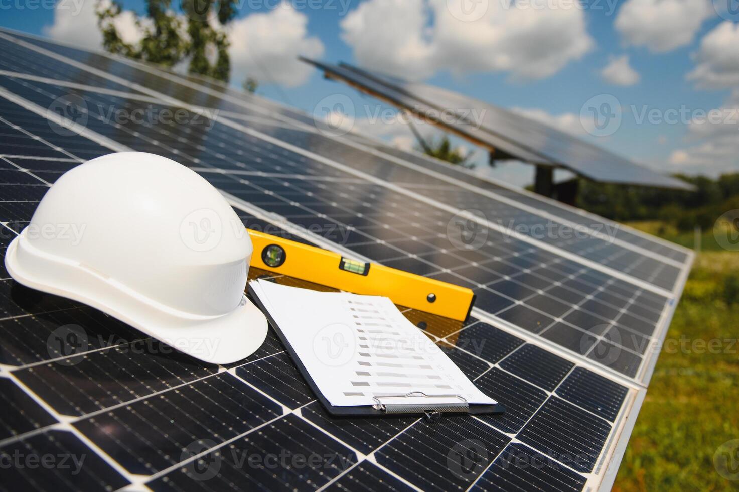 Solar cell contractor document with orange engineering team helmet on solar cells panels. Renewable energy and ecology concept. photo