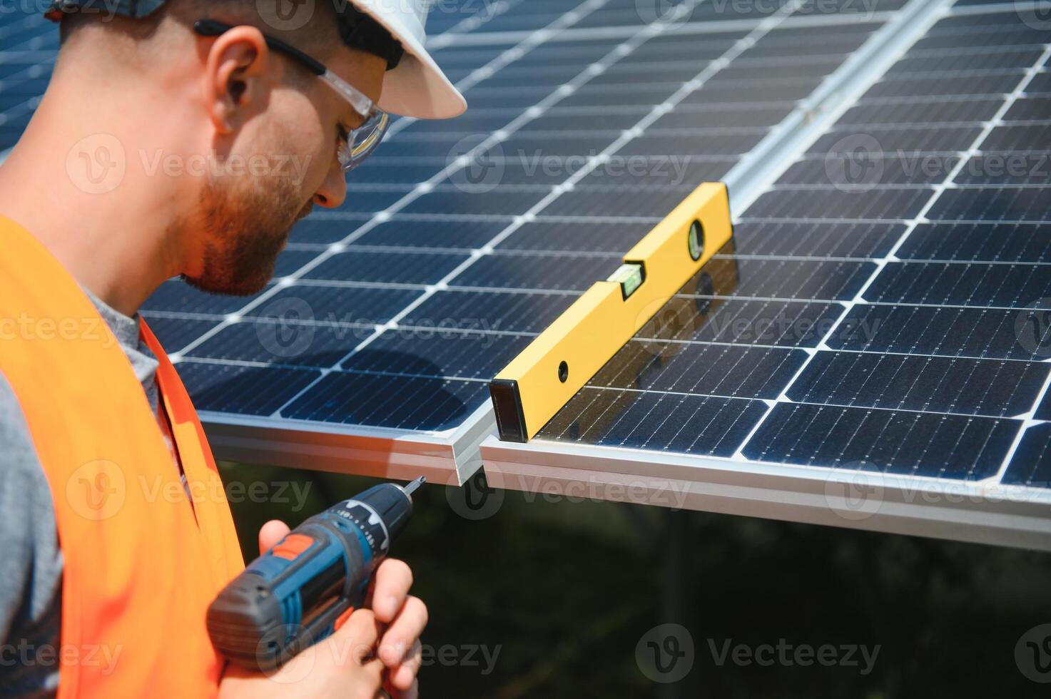 Male engineer in protective helmet installing solar photovoltaic panel system. Alternative energy ecological concept. photo