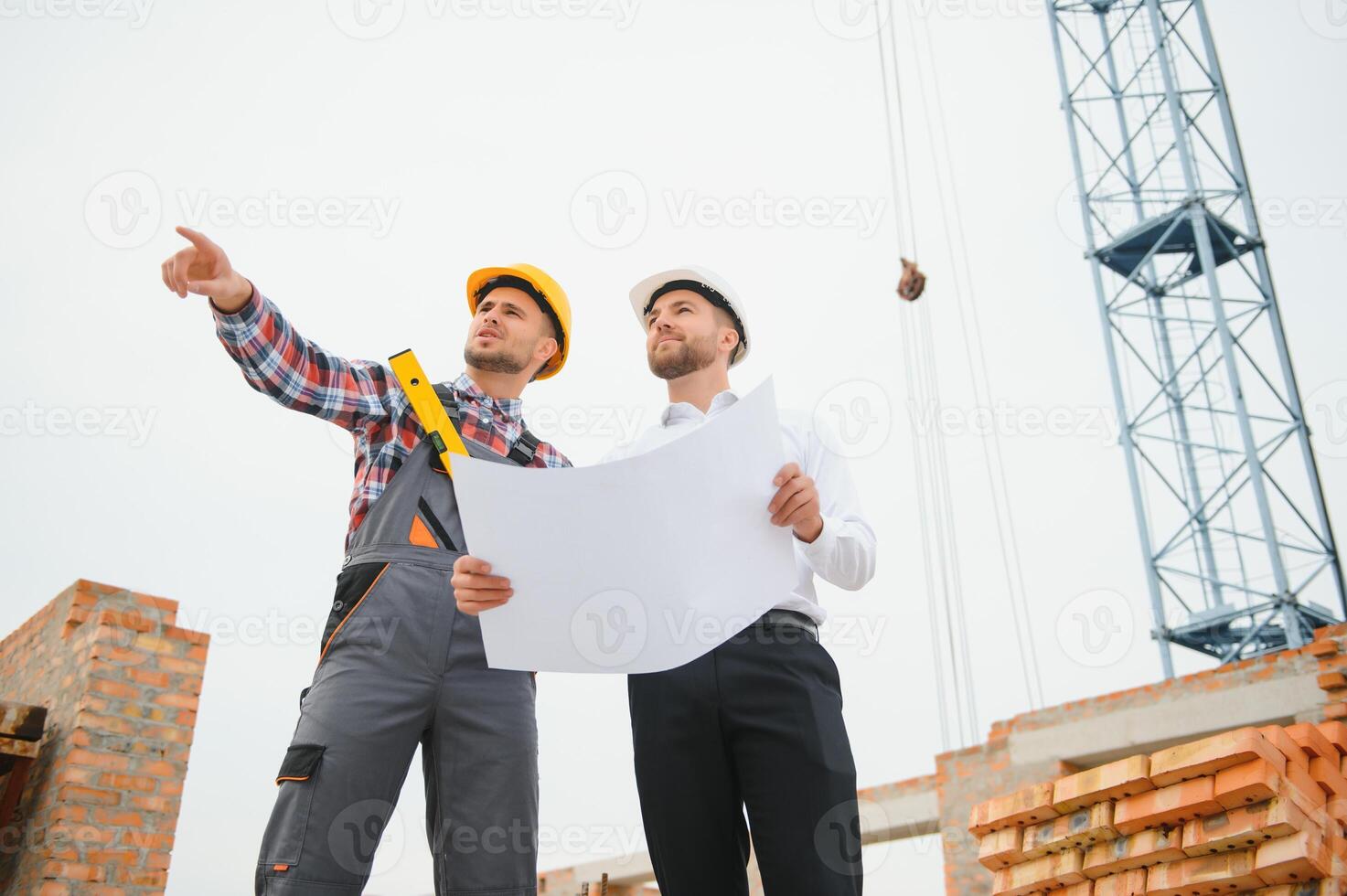 Structural engineer and foreman worker discuss, plan working for the outdoors building construction site photo