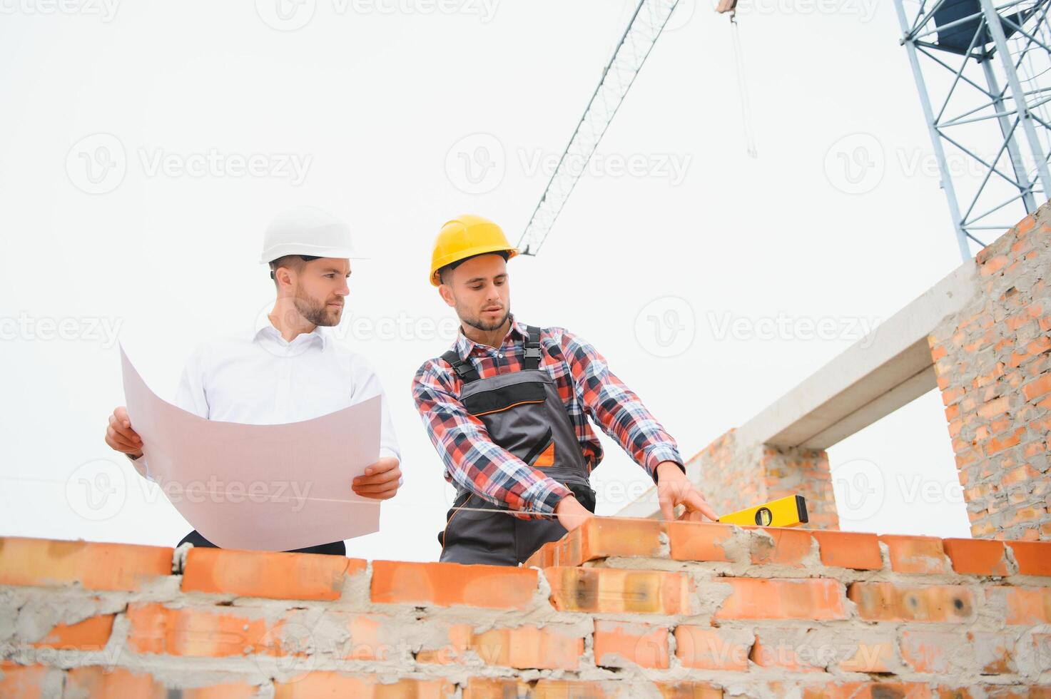 Builder and engineer on construction site photo