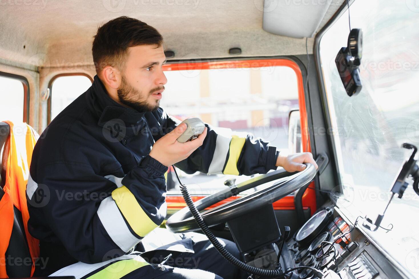 Firefighter using radio set while driving fire truck. photo