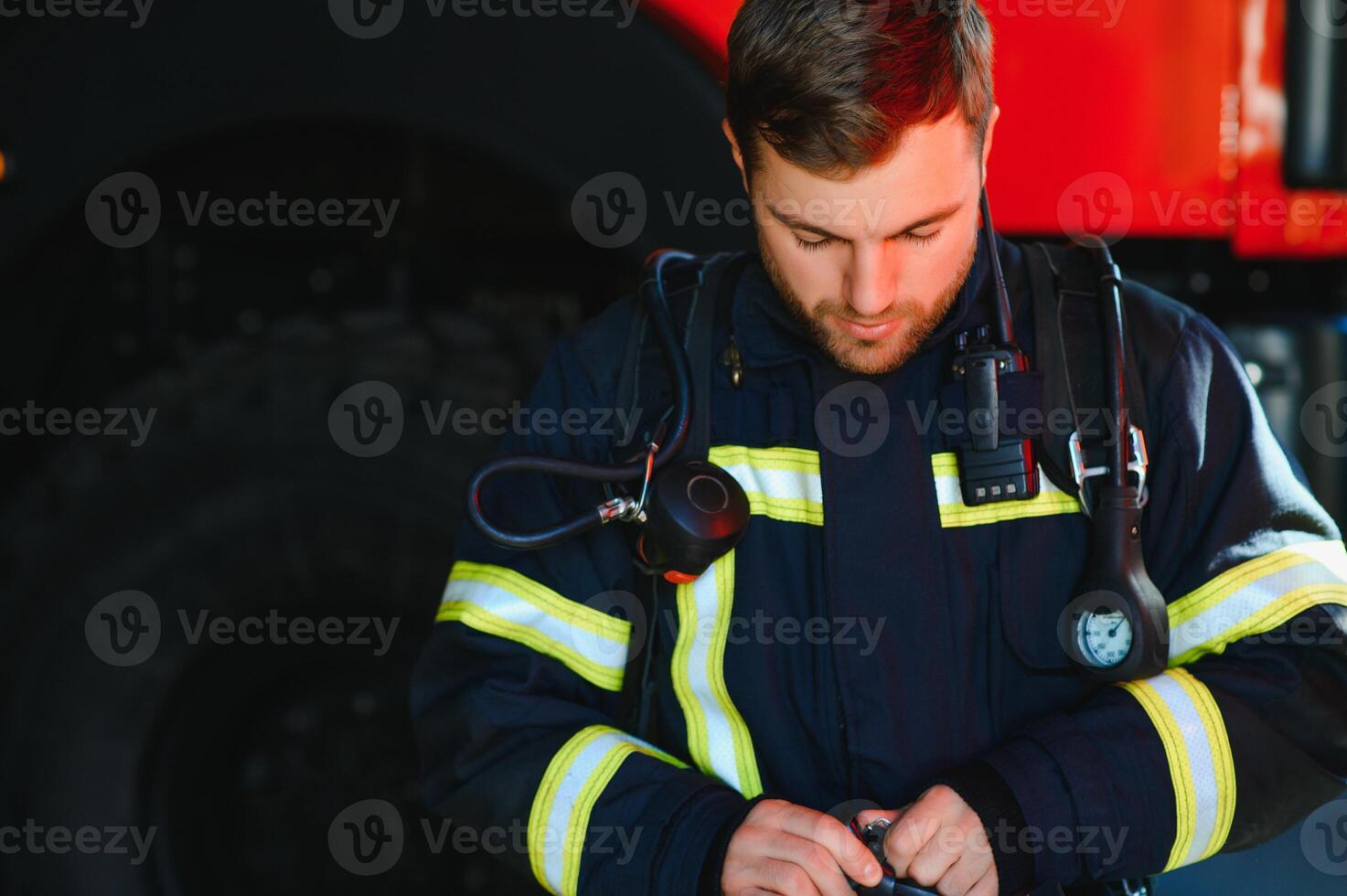 Photo of fireman with gas mask and helmet near fire engine