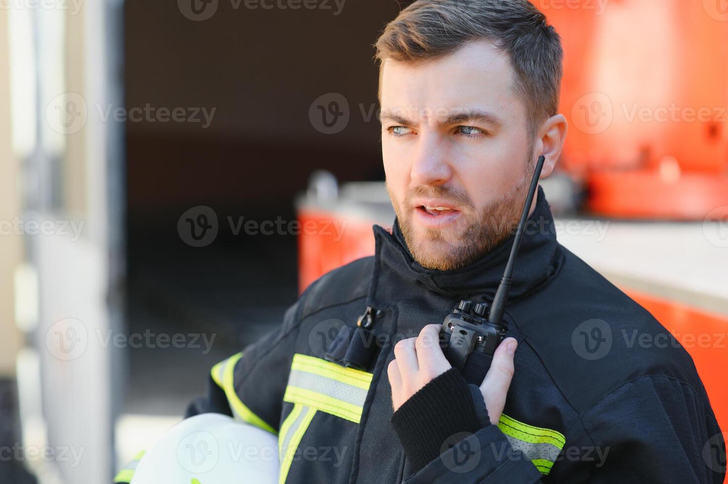 Fireman firefighter in action standing near a firetruck. Emergency safety. Protection, rescue from danger. photo